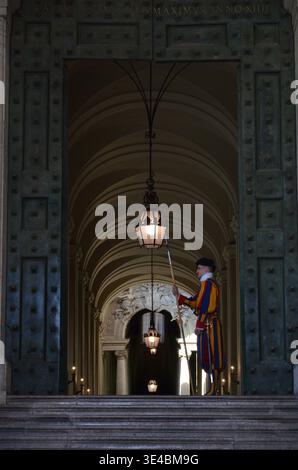 Roma 09.04.2020: La porta di Bronzo della Basilica di San Pietro con la Guardia Svizzera che tiene halberd all'ingresso, città del Vaticano Roma Italia Foto Stock