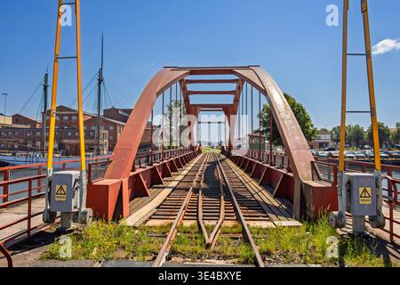 Vecchio ponte ferroviario su un canale con cancelli in una zona industriale Foto Stock