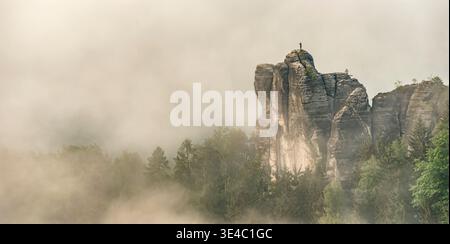 Formazione rocciosa monaca solitaria nel Parco Nazionale della Svizzera sassone, Germania, spettacolari scogliere di arenaria che si innalzano attraverso la nebbia mattutina. Foto Stock