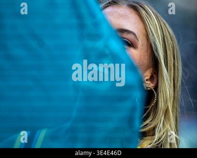 Una donna su un campo da calcio con un bel sorriso nascosto dietro un vail Foto Stock