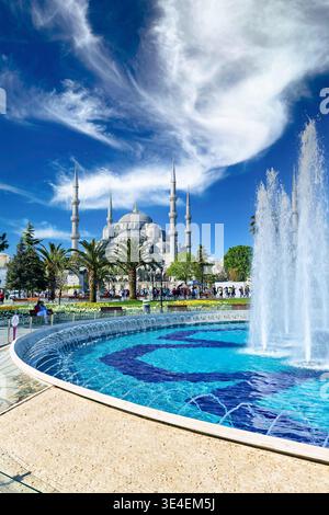 Le persone camminano intorno alla Moschea Blu mentre si godono la vista della fontana e del giardino di Istanbul, in Turchia, durante il bel tempo. Foto Stock