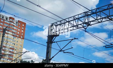 Linee elettriche aeree per il trasporto pubblico elettrico contro il cielo blu e l'edificio di appartamenti Foto Stock