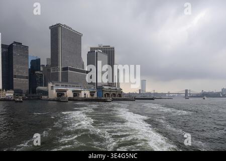 New York NY - USA - Agosto 14 2019: Traghetto per Staten Island sul Porto di New York contro i grattacieli di Lower Manhattan Foto Stock