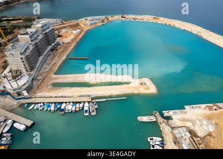 Vista aerea del drone sullo sviluppo di una nuova marina costiera in, mostra la costruzione di appartamenti di lusso e nuove infrastrutture portuali, con le barche attraccate. Par Foto Stock