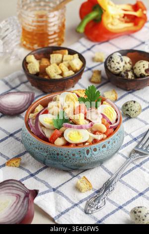 Cibo, deliziosa insalata di filetto di pollo, peperone, fagioli bianchi, uova di quaglia, crostini di pane, cipolla rossa e prezzemolo con salsa di olio d'oliva, mustar Foto Stock