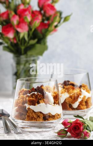 Cibo, piccolo dessert con caramello, biscotti, formaggio spalmabile, panna montata e uvetta. Deliziosi dessert a strati per buongustai. Dolce regalo. Selettivo per Foto Stock
