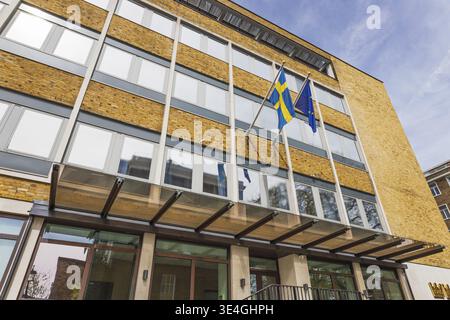 L'Ambasciata di Svezia presenta una moderna facciata in vetro, esterno in mattoni e bandiera svedese. Londra, Regno Unito, 14 aprile 2024 Foto Stock