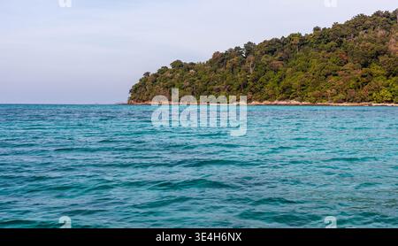 Costa di Koh Adang nel Parco Nazionale di Tarutao. Isola tropicale con vegetazione lussureggiante. Acque turchesi del Mare delle Andamane. Foto Stock