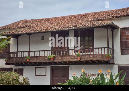 Icod de los Vinos, Tenerife, Spagna, 15 gennaio 2026, case padronali in stile coloniale con i loro iconici balconi in legno intagliato fiancheggiano una tranquilla piazza di Icod Foto Stock