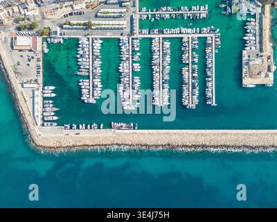 Panorama aereo del porto turistico di Moraira ad Alicante, in Spagna, con file di yacht e barche a vela ormeggiate nel turchese Mar Mediterraneo, frangiflutti e porto Foto Stock