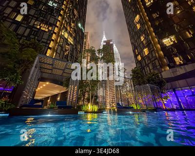 Kuala Lumpur, Malesia: Moderna piscina a sfioro con vista panoramica notturna di Kuala Lumpur Foto Stock