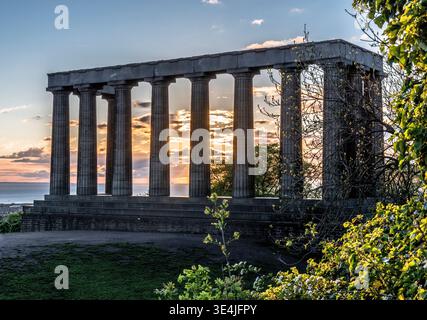 I pilastri di Calton e il monumento nazionale incompiuto si trovano su Calton Hill incorniciati da un suggestivo cielo al tramonto, che offre colonne classiche e atmosfere storiche Foto Stock
