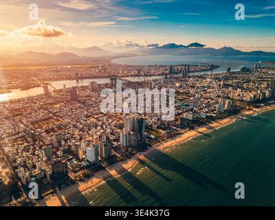 Tramonto soleggiato nella città costiera vietnamita di da Nang, spiaggia di sabbia di My Khe e quartiere turistico di My An and Son tra con moderni hotel e resort grattacieli Foto Stock