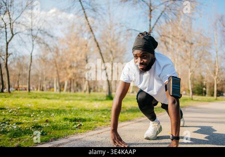Atleta maschile che corre durante gli allenamenti all'aperto nel parco Foto Stock