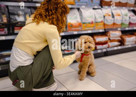 Donna in un negozio di animali con un cane Foto Stock