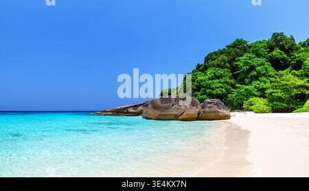 Splendida spiaggia tropicale con sabbia bianca, mare turchese, rocce costiere e lussureggiante vegetazione verde sulle Isole Similan, vicino a Phuket in Thailandia. Foto Stock