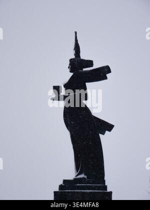Silhouette di profilo del monumento "Madre Armenia" sotto un cielo invernale innevato, su sfondo grigio, Gyumri Armenia Foto Stock
