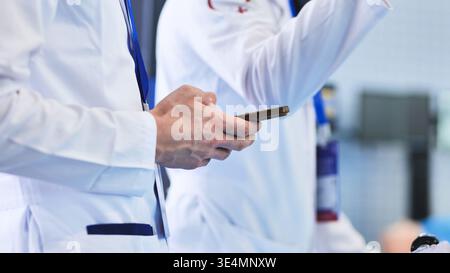 Medico che utilizza lo smartphone per la comunicazione digitale e la tecnologia sanitaria Foto Stock