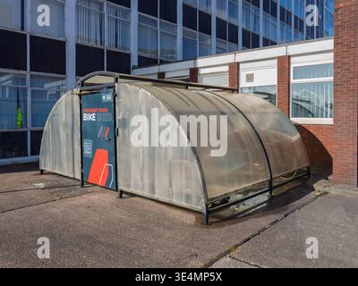 Salford, Manchester, Regno Unito, 28 marzo 2026: Moderno capannone per biciclette con coperchio trasparente vicino all'edificio degli uffici dell'università di Salford. Foto Stock