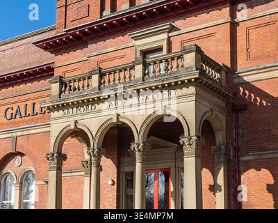 Salford, Manchester, Regno Unito, 28 marzo 2026: Salford Manchester. Storica galleria d'arte in mattoni rossi con archi in pietra ornati sotto il cielo azzurro. Foto Stock