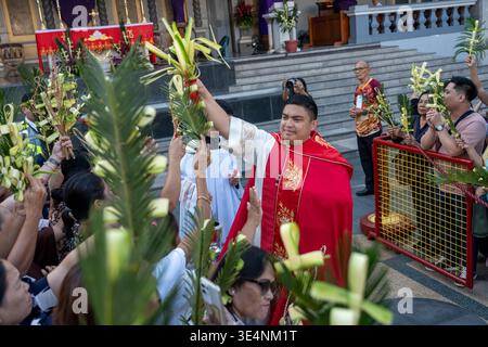Il sacerdote cattolico benedice le croci di palme tenute dai fedeli durante la celebrazione della domenica delle Palme presso la Basilica del Santo Niño Cebu City Filippine Foto Stock