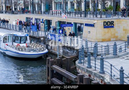 I visitatori che aspettano fuori dal DDR Museum di Berlino vicino al fiume Sprea, fotografati dal ponte Liebknecht nel centro di Berlino, Germania. Foto Stock