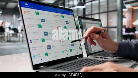 Giovane sicuro di sé che esplora le opportunità di lavoro online e pianifica i colloqui Foto Stock