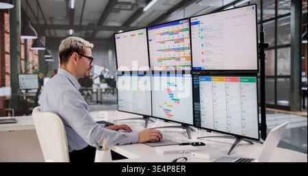 Hispanic software Engineer semplifica il flusso di lavoro giornaliero utilizzando strumenti di gestione delle attività basati su computer in Office Foto Stock