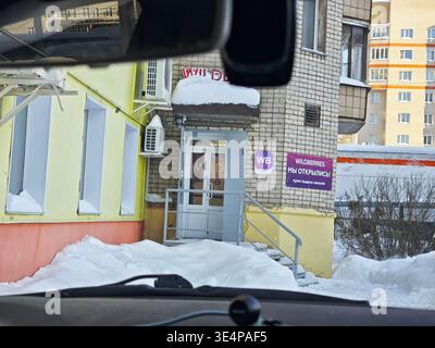 Kirov, Russia - 8 febbraio 2026: I clienti si avvicinano al negozio online Wildberries che mostra un ingresso marcato con la neve intorno. Il negozio fa parte Foto Stock