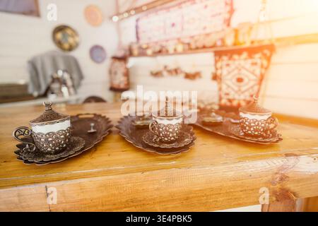 Tre tazze da caffè turche ornate su un tavolo di legno Foto Stock