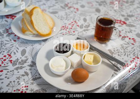 Un gran numero di piatti per la colazione per bambini a scuola o dipendenti di aziende. Su un piatto di uova, miele, formaggio e formaggio fresco Foto Stock