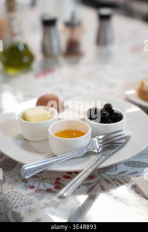 Un gran numero di piatti per la colazione per bambini a scuola o dipendenti di aziende. Su un piatto di uova, miele, formaggio e formaggio fresco Foto Stock