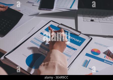 Tabella riportata sopra con documenti finanziari, grafici e big data durante la riunione di lavoro di squadra con il team di contabilità o marketing che discute di budget, strategia o crescita d Foto Stock