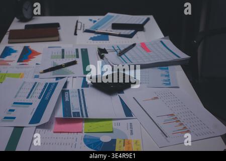 Tabella riportata sopra con documenti finanziari, grafici e big data durante la riunione di lavoro di squadra con il team di contabilità o marketing che discute di budget, strategia o crescita d Foto Stock