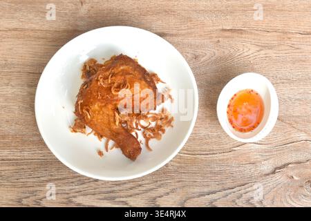 pollo fritto croccante stretto e coscia con scalogno sul piatto e salsa al peperoncino dolce in tazza Foto Stock
