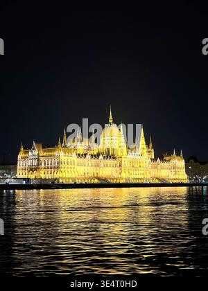Luci dorate dell'edificio del Parlamento ungherese di notte con splendidi riflessi sul fiume Danubio. Simbolo di Budapest, Ungheria. Foto Stock