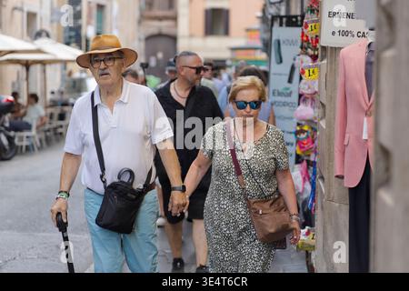due anziani turisti a roma che camminano mano nel cappello a mano, svegliando un bastone e una coppia di donne Foto Stock