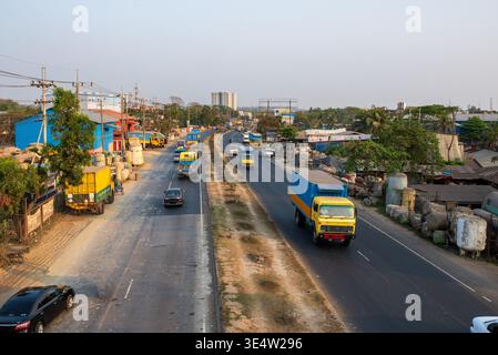 Vista sopraelevata dell'autostrada Dhaka-Chittagong. La foto mostra camion e auto colorate che guidano su corsie asfaltate. Lungo la strada, c'è la guerra blu Foto Stock