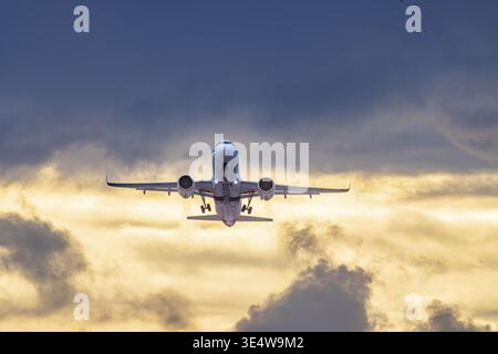 Aeroporto di Stoccarda con l'aereo in decollo. Eurowings Airbus A320 di fronte a nuvole buie, illuminati di sera. Stoccarda, Baden-Wuerttemberg, tedesco Foto Stock