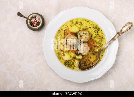 Cibo, zuppa deliziosa con polpette di pollo o tacchino con verdure - patate, carote, aneto, prezzemolo e spezie in un piatto bianco. Messa a fuoco selettiva Foto Stock