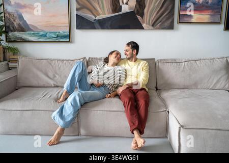 Marito e moglie allegri coppie sposate si siedono su un comodo divano nel soggiorno godendo di un momento romantico. Foto Stock