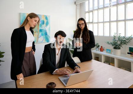 Persone aziendali che collaborano con un notebook in un ufficio moderno Foto Stock