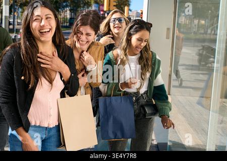 Gruppo di donne allegre che ridono divertendosi a fare shopping Foto Stock