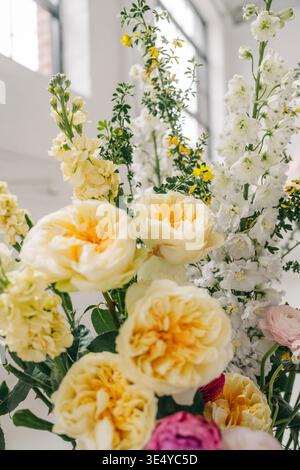 Rose gialle delfinio bianco composizione floreale a molla Foto Stock