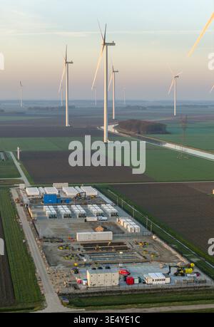 Vista aerea di un sistema di accumulo di energia su larga scala con numerose turbine eoliche che generano energia rinnovabile in un paesaggio rurale Foto Stock