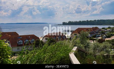 Panoramablick vom Schmiedeberg über die roten Dächer von Rerik auf das Salzhaff und die Halbinsel Wustrow an der Ostseeküste bei Sonnenlicht Foto Stock