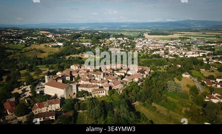 Veduta aerea di un villaggio medievale fortificato, con la sua chiesa, circondato da una lussureggiante campagna, Pérouges, Auvergne-Rhône-Alpes, Francia. Foto Stock