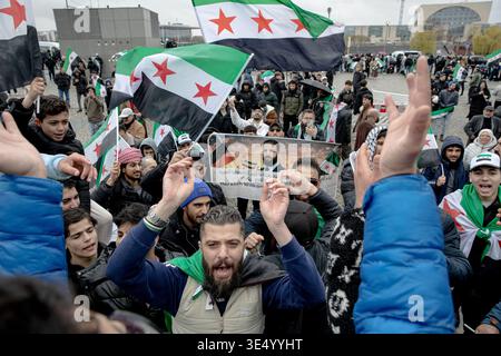 Lunedì 30 marzo 2026, i sostenitori del presidente siriano Ahmed al-Sharaa tengono striscioni e ondeggiano bandiere siriane verdi, bianche e nere con tre stelle rosse a Washingtonplatz vicino alla stazione centrale di Berlino durante la sua visita in Germania. Un grande striscione che recita „benvenuto Presidente“ e i ritratti di al-Sharaa sono stati esposti come dimostranti riuniti a sostegno, poiché la Siria rimane in un periodo politico di transizione dopo la caduta di Bashar al-Assad. (Foto di Michael Kuenne/PRESSCOV/Sipa USA) Foto Stock