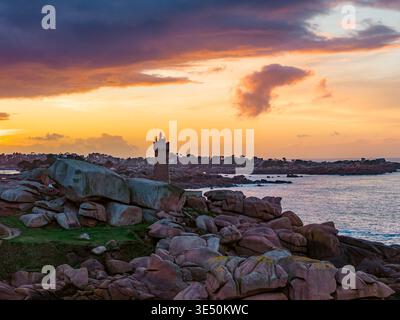 Veduta aerea del faro di Ploumanaca'h in piedi tra le iconiche rocce di granito rosa sotto un vivace cielo al tramonto a Perros-Guirec, in Bretagna, in Francia. Foto Stock