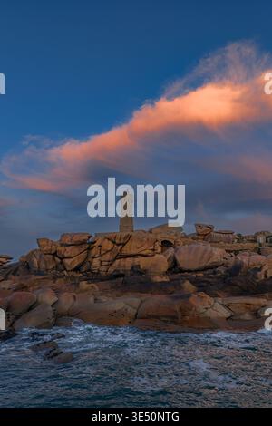 Veduta aerea del faro di Ploumanaca'h in piedi su rocce di granito rosa sotto una nuvola luminosa al tramonto a Perros-Guirec, Bretagna, Francia. Foto Stock